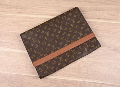 une pochette Louis Vuitton posée sur un parquet