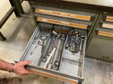 un homme en train d'ouvrir un tiroir contenant des outils
