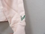 a person wearing a white shirt with green writing on it