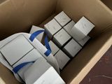a cardboard box filled with white boxes and blue ribbon