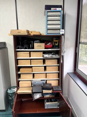 a wooden cabinet with many boxes on top of it