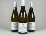 trois bouteilles de vin blanc posées sur une table