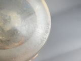 une personne tenant un verre dans lequel se reflète l'image d'une autre personne