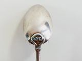 a silver spoon with a metal handle on a table