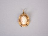 a close up of a gold pendant with a picture of a woman ' s face