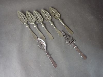 cinq cuillères en argent et un couteau sur une table