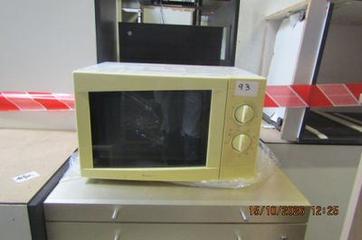 un micro-ondes posé sur un bureau dans une pièce