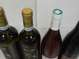 several bottles of wine are lined up on a counter