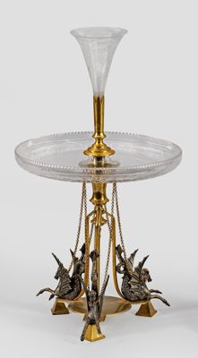 a glass table with a gold base and two birds on it