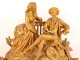 a gold statue of a man and a woman sitting on a bench
