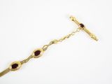 une photo d'un bracelet en or orné de grenats