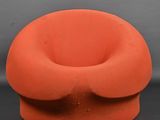 une chaise orange posée sur une surface noire
