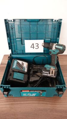 quelques outils rangés dans une mallette bleue posée sur une table en bois