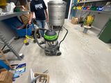 a man that is standing in a room with a vacuum