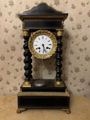 a black and gold clock sitting on top of a table