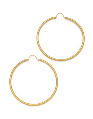 une paire de boucles d'oreilles en or sur fond blanc