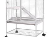 une grande cage à oiseaux blanche, munie de roulettes et d'une échelle