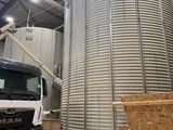 un camion garé devant un grand silo