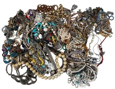 a pile of assorted necklaces and bracelets on a white surface