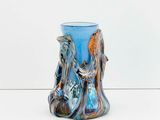 a blue vase with an elephant on it on a white surface