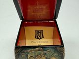 a small box with a painting on it on a table