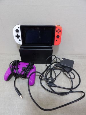 une console de jeux Nintendo Wii avec deux manettes et un chargeur