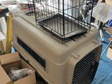 a cat in a cage sitting on top of a pile of boxes