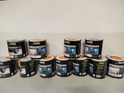 several cans of paint sitting on a shelf in a room