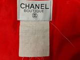 a red chanel coat with a white label on it