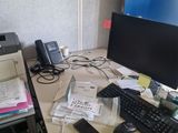 a desk with a computer, printer, cell phone, and other office supplies on it
