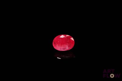 a close up of a red stone on a black surface