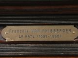 an image of a plaque on the side of a wooden cabinet
