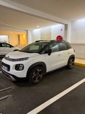 a small white car parked in a parking lot