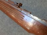 an old rifle with a wooden barrel on a gray surface