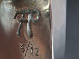 a close up of a silver plate with a bird on it
