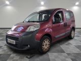 a small red van parked in a room with checkered floor