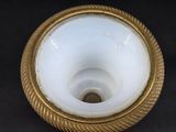 a white vase with a gold rim on a table