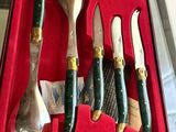 four knives and a fork in a box on a table