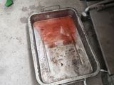 une personne debout à côté d'une casserole sale posée par terre
