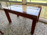 a table with a glass top on a tiled floor