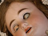 a close up of a doll ' s face with a bonnet on