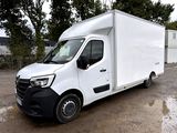 une camionnette blanche garée sur un parking, avec des arbres en arrière-plan