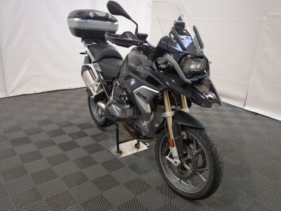 une moto qui est garée dans une pièce dont le sol est en damier