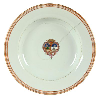 une image représentant une assiette blanche à bord doré, sur laquelle figure un blason