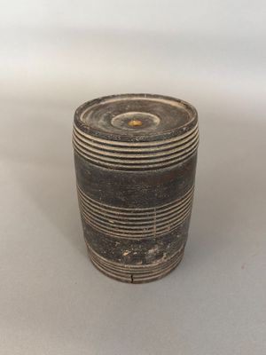 un vase noir et blanc posé sur une surface blanche