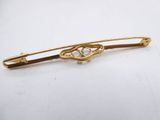 a close up of a gold brooch with a knot on it