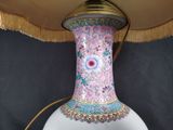 a white vase with a pink and blue design on it