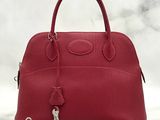 a red leather handbag with a key on a white background