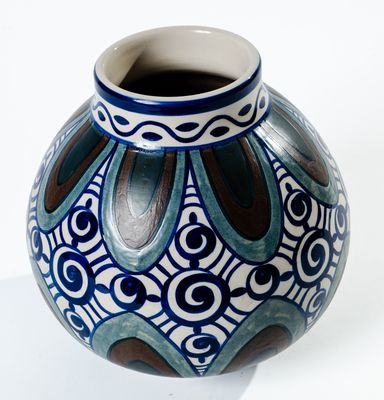 un vase bleu et blanc posé sur une surface blanche