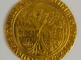 a close up of a gold coin with a coat of arms on it